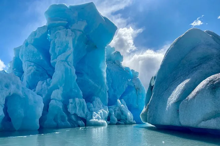 Close-up view of towering, bright blue ice formations in the water